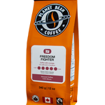 Orange coffee bag with 'Planet Bean Coffee' branding on a white background label that reads Freedom Fighter - Ground Coffee