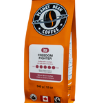 Orange coffee bag labeled 'Freedom Fighter' from Planet Bean Coffee on a white background label that reads Freedom Fighter - Whole Bean Coffee